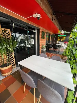 a white table and chairs in front of a restaurant at Hotel boutique San Pablo H10 in Medellín