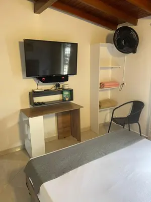 a bedroom with a television on a table with a chair at Hotel boutique San Pablo H10 in Medellín