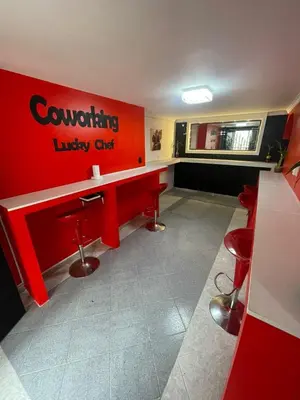 a waiting room with a red counter and red stools at Hotel boutique San Pablo H10 in Medellín