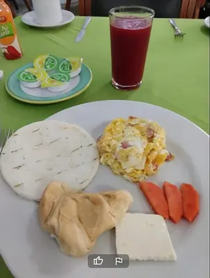 a white plate with food on a table at Hotel Laureles 70 Medellín in Medellín