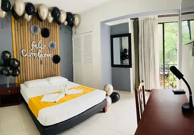a bedroom with a bed and a desk with a mirror at Hotel Laureles 70 Medellín in Medellín