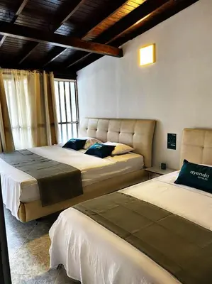a bedroom with two beds in a room at Hotel boutique San Pablo H3 in Medellín