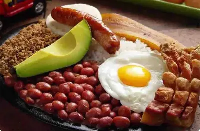 a plate of breakfast food with eggs bacon and nuts at Hotel boutique San Pablo H3 in Medellín