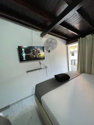 a bedroom with a bed and a flat screen tv at Hotel boutique San Pablo H3 in Medellín