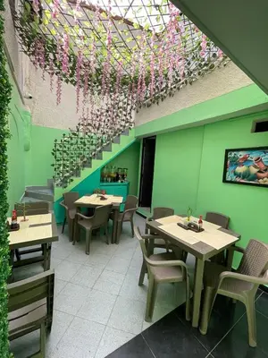 a restaurant with tables and chairs and a ceiling with flowers at Hotel boutique San Pablo H3 in Medellín