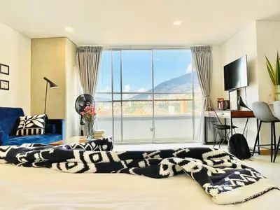 a bedroom with a bed with a large window with a view at Loft luminoso y moderno con excelentes vistas in Medellín