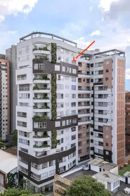 a tall white building with a red arrow on it at Loft luminoso y moderno con excelentes vistas in Medellín