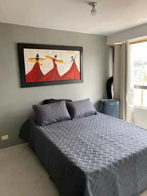 a bedroom with a bed and a painting on the wall at En la cima y en el corazón de Medellín in Medellín