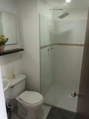 a bathroom with a toilet and a glass shower at En la cima y en el corazón de Medellín in Medellín
