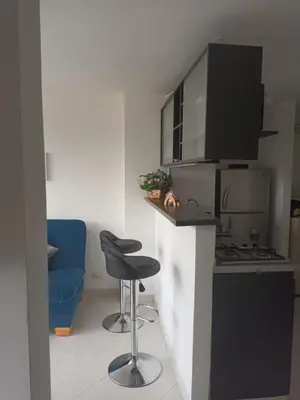 a kitchen with a stove and a blue chair at En la cima y en el corazón de Medellín in Medellín