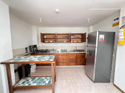 a kitchen with a stainless steel refrigerator and a table at Casa colonial acogedora cerca al parque in Jardin