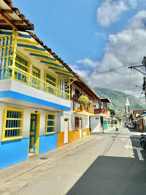 an empty street with a yellow and blue building at Casa colonial acogedora cerca al parque in Jardin
