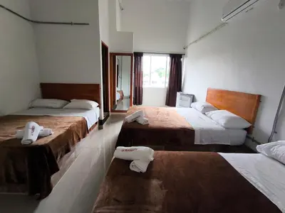 a hotel room with two beds and a window at LA PLAZOLETA in Doradal