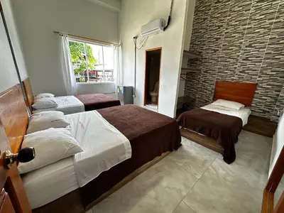 a bedroom with two beds and a brick wall at LA PLAZOLETA in Doradal