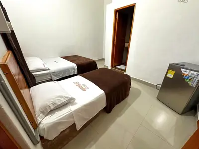 a small room with two beds and a television at LA PLAZOLETA in Doradal