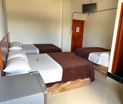 a hotel room with two beds and a television at LA PLAZOLETA in Doradal