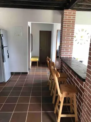 a room with two chairs and a kitchen with a clock at Desconéctate! Casa de campo con vista sensacional !!! in Rionegro