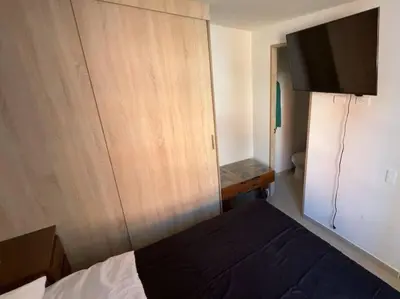 a bedroom with a bed and a cabinet and a television at Apartamento campestre a 5 min del parque in La Ceja
