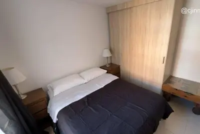 a bedroom with a bed and two tables and a window at Apartamento campestre a 5 min del parque in La Ceja