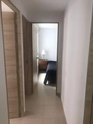 a hallway with a room with a bed and a mirror at Apartamento campestre a 5 min del parque in La Ceja