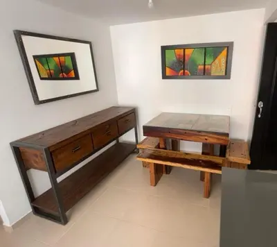 a room with a table and a bench and two paintings at Apartamento campestre a 5 min del parque in La Ceja
