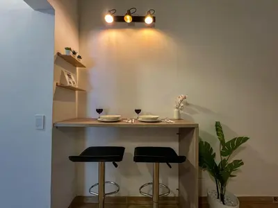 a bar with two stools and a table in a room at 202 Romantic loft with jacuzzi in Medellín