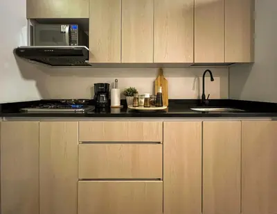 a kitchen with wooden cabinets and a sink and a microwave at 202 Romantic loft with jacuzzi in Medellín