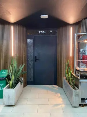 a black door in a lobby with two plants at 202 Romantic loft with jacuzzi in Medellín