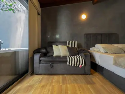a living room with a couch and a bed at 202 Romantic loft with jacuzzi in Medellín