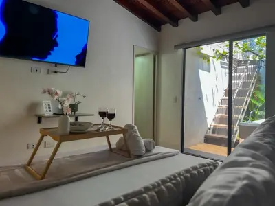a living room with a table and a tv on the wall at 202 Romantic loft with jacuzzi in Medellín