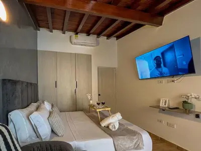 a bedroom with a bed with a tv on the wall at 202 Romantic loft with jacuzzi in Medellín