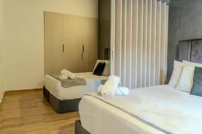 a bedroom with two beds with white sheets at 203 Enigmatic Loft with Jacuzzi in Medellín