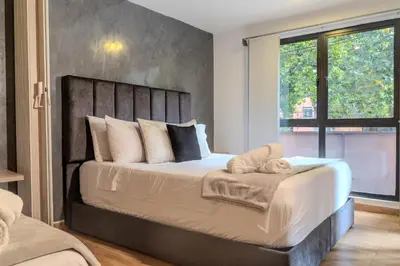 a bedroom with a large bed with a large window at 203 Enigmatic Loft with Jacuzzi in Medellín