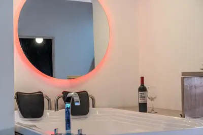 a bathroom with a sink and a bottle of wine at 203 Enigmatic Loft with Jacuzzi in Medellín