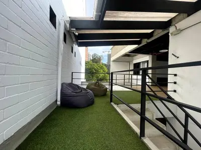 a balcony with green grass on the side of a building at Económicas habitaciones amobladas en Medellín con oficinas, puesto de trabajo, cocina, baño y lavandería comunes Be Together by Roots Rentals TOG401y402 in Medellín