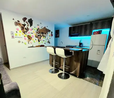 a kitchen with a bar with two stools and a refrigerator at Apartamento en Jardín Antioquia in Jardin