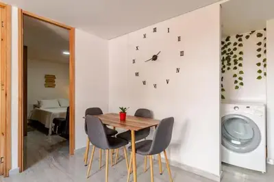 a dining room with a table and a clock on the wall at Apartamento centro Marinilla in Marinilla