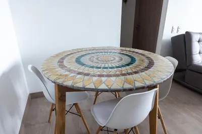 a table with white chairs and a mosaic table at Hermoso Apartamento exclusiva ubicación in Manizales