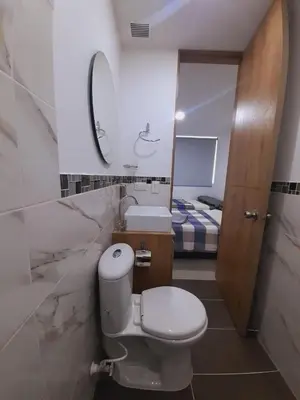 a bathroom with a toilet and a sink and a bed at Disole 504 in Santa Fe de Antioquia