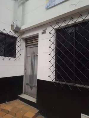 a white building with a door and a window at Casa Familiar- Turística Manríque Medellín in Medellín