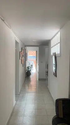 a hallway with white walls and a tile floor at Casa Familiar- Turística Manríque Medellín in Medellín