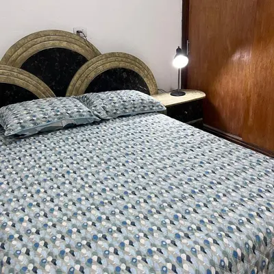 a bedroom with a bed with a blue patterned blanket at Casa Familiar- Turística Manríque Medellín in Medellín