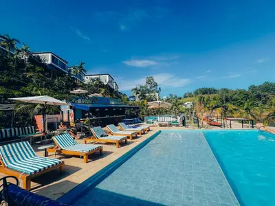 a pool with chaise lounge chairs and a swimming pool at Viajero Guatapé Hostel & Lake Club in Guatapé