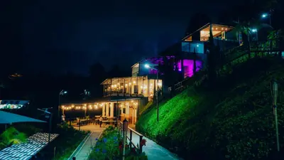 a house with lights on the side of a hill at Viajero Guatapé Hostel & Lake Club in Guatapé