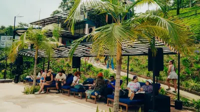 a group of people sitting in chairs under an umbrella at Viajero Guatapé Hostel & Lake Club in Guatapé