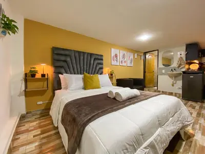 a bedroom with a large white bed with yellow walls at Harmony loft - Apto con Wifi de 200Mbp Cercano a todo in Carmen de Viboral