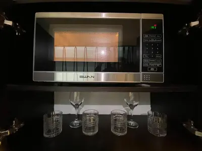 a microwave sitting on a shelf with wine glasses at Harmony loft - Apto con Wifi de 200Mbp Cercano a todo in Carmen de Viboral