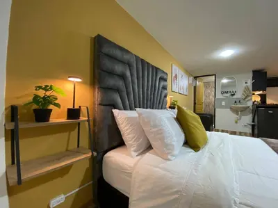 a bedroom with a bed with a black headboard at Harmony loft - Apto con Wifi de 200Mbp Cercano a todo in Carmen de Viboral