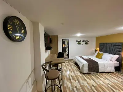 a hotel room with a bed and a clock on the wall at Harmony loft - Apto con Wifi de 200Mbp Cercano a todo in Carmen de Viboral