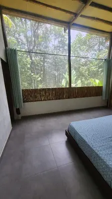a bedroom with a bed and a large window at Casa Kiwi Jungle Lodge in San Francisco